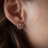 Eine Frau trägt einen Ohrring mit Brezen-Motiv