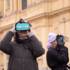 Zwei Frauen stehen im Winter mit VR-Brillen von TimeRide Go vor der Theatinerkirche in München.