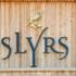 Das Logo der Slyrs Destillerie auf einem Holzhaus