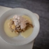 Eine Mehlspeise mit Vanillesoße und Puderzucker auf einem weißen Teller
