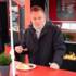 Der Sternekoch Stefan Barnhusen isst eine Currywurst bei Schneds Gourmet Grill
