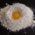 Ein aufgeschlagenes Ei in einem Haufen Mehl