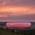Die Allianz Arena in M&uuml;nchen leuchtet rot im Abendlicht.