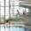 Eine Frau im Badeanzug springt in der Schwimmhalle vom 3-Meter-Brett