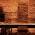 Tables and benches are arranged in the vaulted cellar of Augustiner-Keller in Munich with brick walls and indirect lighting.