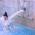 Una mujer en bikini est&aacute; de pie bajo una fuente de agua que brota de una boca de le&oacute;n de piedra en la piscina p&uacute;blica &laquo;M&uuml;ller'sches Volksbad&raquo; de M&uacute;nich.