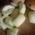 Geschnittene Apfelstücke liegen neben einem Rosinenbrot auf einem Holzbrett