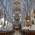 Innenansicht der Peterskirche in München, vergoldete Statuen, goldene Kanzel, prunkvoller Altar und Deckenmalerei.