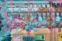 Eine Wand mit t&uuml;rkis-pinkem Grafitti in M&uuml;nchen.