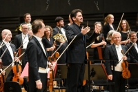 Mehrere Musiker und Musikerinnen in Abendgarderobe spielen im Orchester der M&uuml;nchner Philharmoniker