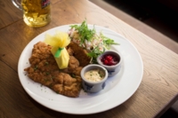 A Wiener schnitzel on a white porcelain plate in a Munich restaurant.