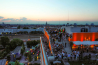 Blick auf die Hoch 5 Dachterrasse und die M&uuml;nchner Skyline am Abend.