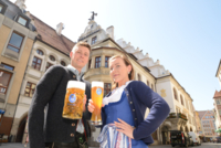 Junger Mann mit Ma&szlig; Bier und junge Frau mit Wei&szlig;bier vor dem Hofbr&auml;uhaus in M&uuml;nchen