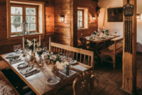 Holzstube in der Alm mit gedeckten Tischen
