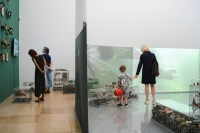 Mehrere Besucherinnen sehen sich die Ausstellung Eisbach Treasures im Haus der Kunst an