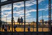 2 people sitting on the Hackerbr&uuml;cke at sunset in Munich