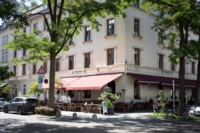 In einem Altbauhaus befindet sich im Erdgeschoss ein Restaurant mit Terrasse