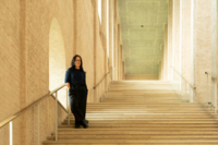 M&uuml;nchen-Botschafterin Laura Schieferle steht auf einer imposanten Steintreppe in einem Museum im Kunstareal.