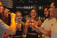 A group of friends toasting with a glass of wine.