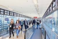 Messebesucher auf dem Weg und Laufband zwischen den Hallen