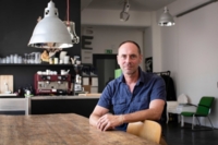 David S&uuml;&szlig; sits at a table in his apartment in Munich.