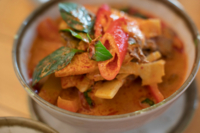 Sch&uuml;ssel mit thail&auml;ndischem Gericht aus roten Paprika, Thaibasilikum und weiteren asiatischen Zutaten