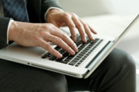 Ein Mann tippt an seinem Laptop.