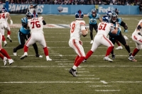 Bei einem NFL Spiel in M&uuml;nchen stehen mehrere Spieler in Trikots und Helmen auf dem Rasen