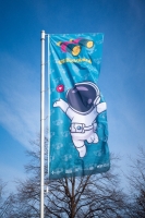 Eine blaue Flagge der GG Bavaria mit einem Comic-Astronaut h&auml;ngt in M&uuml;nchen an einem Fahnenmast.