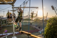 Auf dem Adventure Tower im Olympiapark stehen mehrere Menschen gesichert auf einem Parcour in der Luft