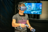 Ein junger Mann nimmt an einem VR Erlebnis in der Jochen Schweizer Arena teil.