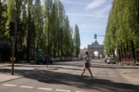 Young woman crosses Leopoldstra&szlig;e in Munich.