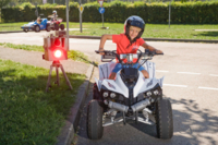 Ein etwa achtj&auml;hriger Junge mit Sturzhelm f&auml;hrt auf einem Verkehrsanlage mit einem Squad.