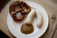 Weissw&uuml;rste mit Bretzel und s&uuml;&szlig;em Senf in M&uuml;nchen.