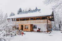 Die Au&szlig;enansicht eines Hauses des Hotels Stubn in einer Schneelandschaft.