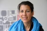 Nadine Vicentini, Leiterin der mcbw, im Portr&auml;t. Sie tr&auml;gt einen blauen Schal und lange, silberfarbene Ohrringe.