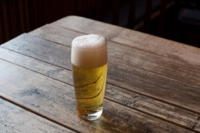 Ein Glas Helles steht auf einem Holztisch in einem Wirtshaus in M&uuml;nchen.