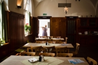 Innenansicht der Gastst&auml;tte Gro&szlig;markthalle in M&uuml;nchen mit einer Kellnerin, die ein Tablett mit Essen nach drau&szlig;en tr&auml;gt.
