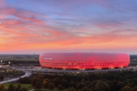 Die Allianz Arena in M&uuml;nchen leuchtet rot im Abendlicht.