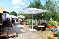 Tische, St&uuml;hle, Sonnenschirme und Container in denen es Getr&auml;nke und Essen gibt im Im Dazwischen.
