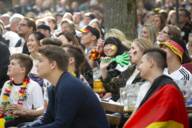 Eine Gruppe von Fans der deutschen Fußball-Nationalmannschaft fiebert mit beim Public Viewing in einem Münchner Biergarten.