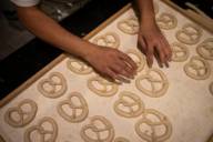 Auf einem Backblech bei Julius Brantner in München liegen Brezen-Teiglinge, die ein Bäcker geformt hat.