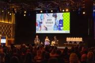 Blick auf die Bühne während dem Vortrag  von Carolin Engelhardt auf dem Tourismustag 2025 in München.