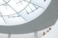 Eine Familie steht im obersten Stockwerk der Pinakothek der Moderne in München und unterhält sich.