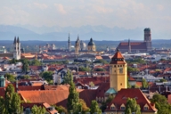 Stadtpanorama von München unter anderem mit den Türmen von Frauenkirche, im Hintergrund die Alpen.
