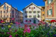 Mehrere bunte Häuser mit Blumen im Vordergrund in Garmisch Partenkirchen.