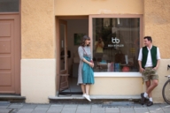 Eine Frau und ein Mann in Tracht stehen vor einem Ladengeschäft