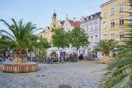 Visitors sitting on a restaurant terrace in Burghausen's town square