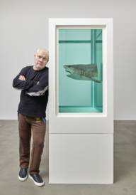 Der britische Bildhauer und Maler Damien Hirst im MUCA neben eines seiner Ausstellungswerke