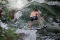 Un surfista sta facendo surf su un'onda all'Eisbach.